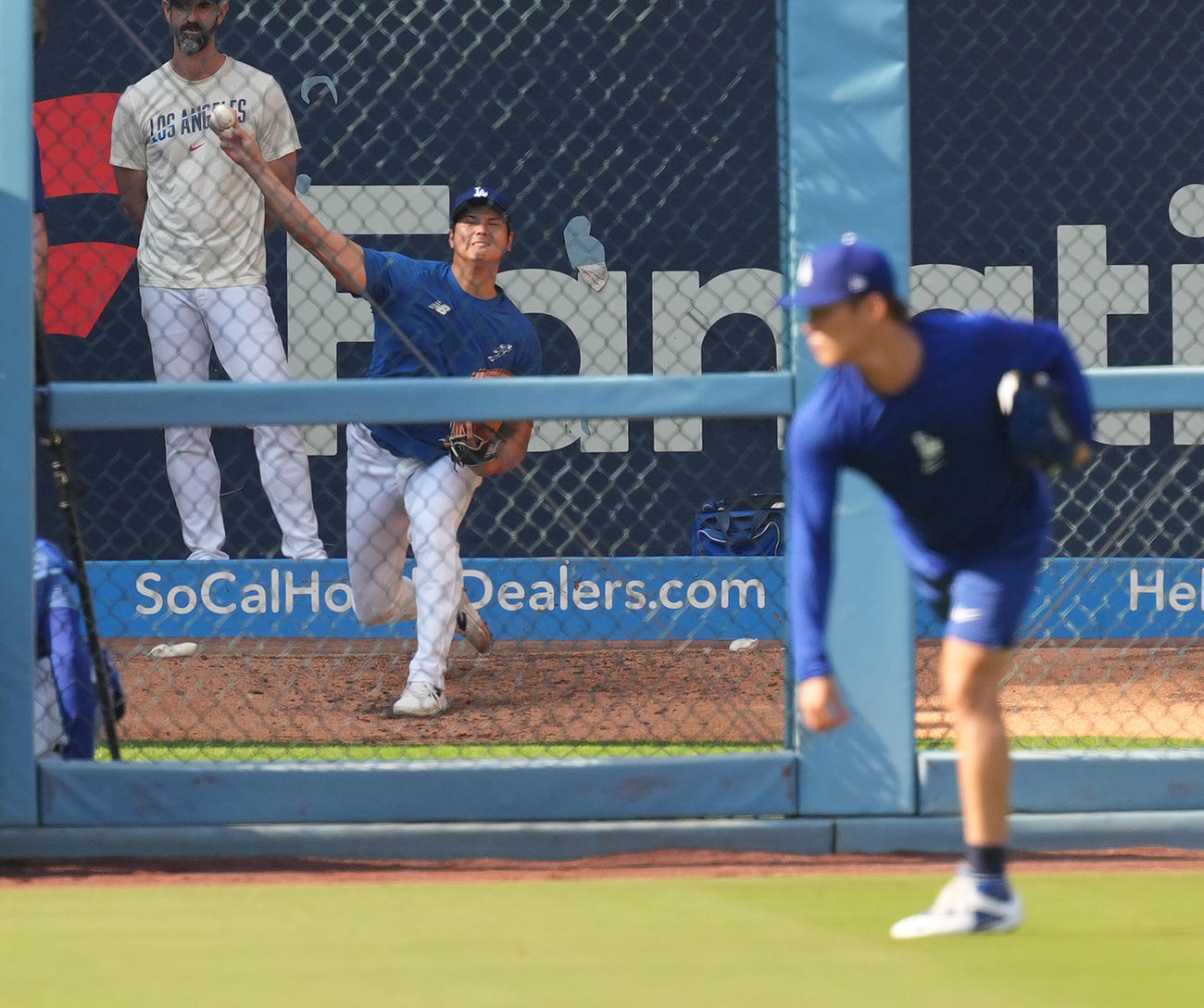 ドジャース対ロッキーズ　試合前、キャッチボールをする山本（手前）を前にブルペンで投球練習をするドジャース大谷（撮影・菅敏）