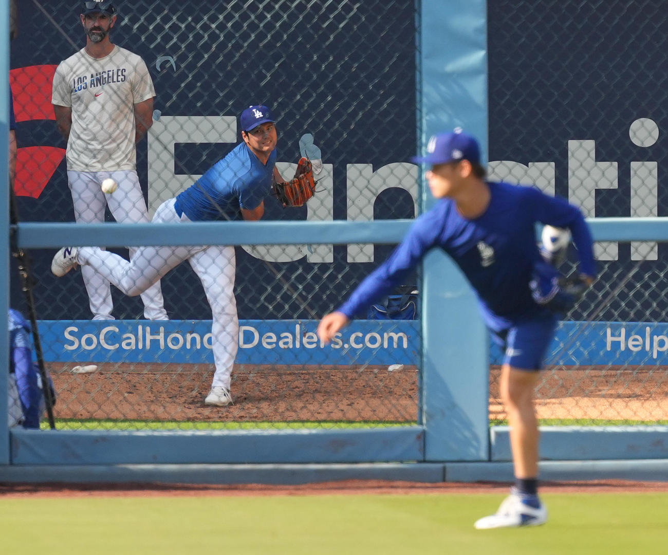 ドジャース対ロッキーズ　試合前、キャッチボールをする山本（手前）を前にブルペンで投球練習をするドジャース大谷（撮影・菅敏）