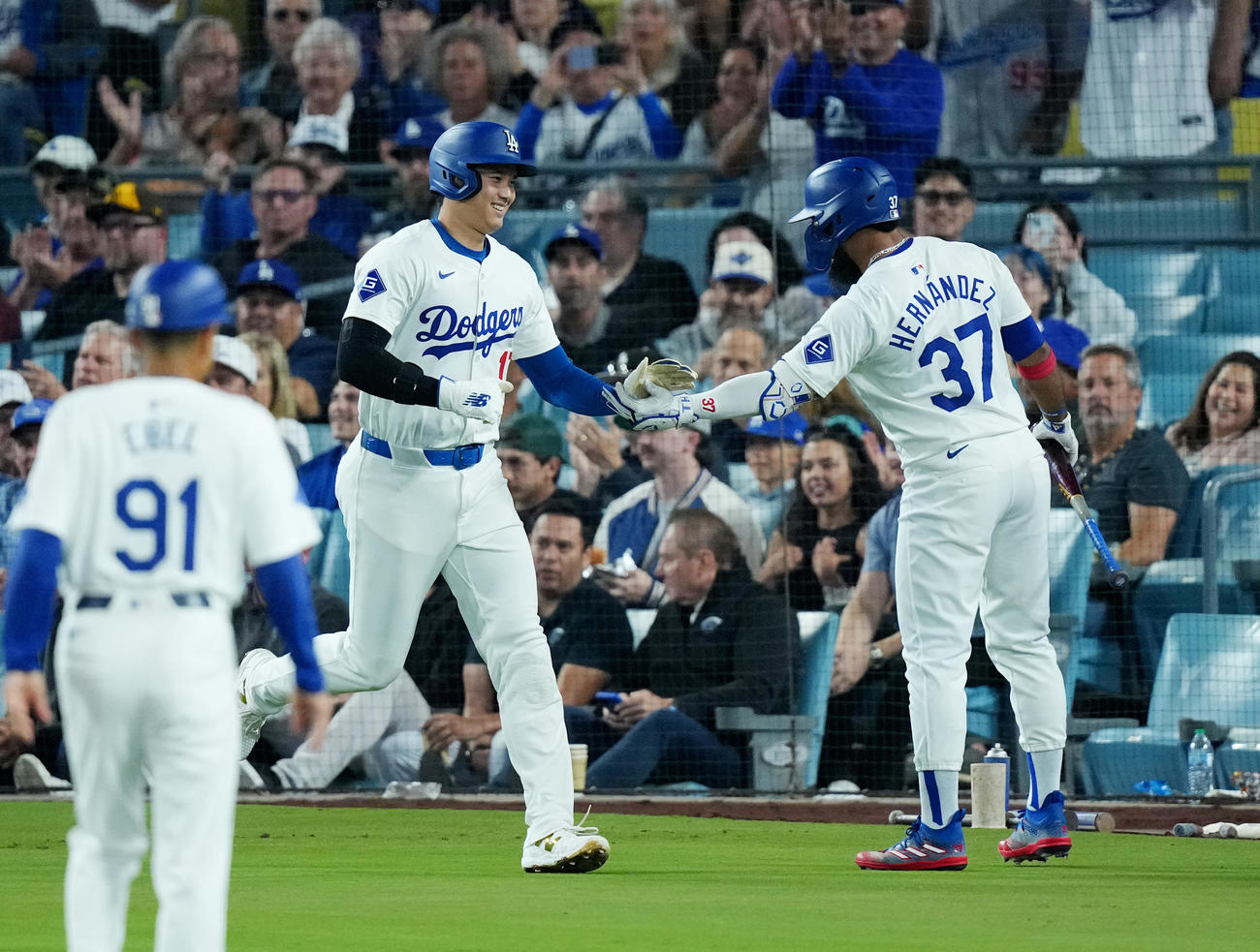 ドジャース対パドレス　1回裏ドジャース無死二塁、ベッツの遊ゴロを相手が悪送球し二塁から生還する大谷は、T・ヘルナンデス（右）にタッチで迎えられる（撮影・菅敏）