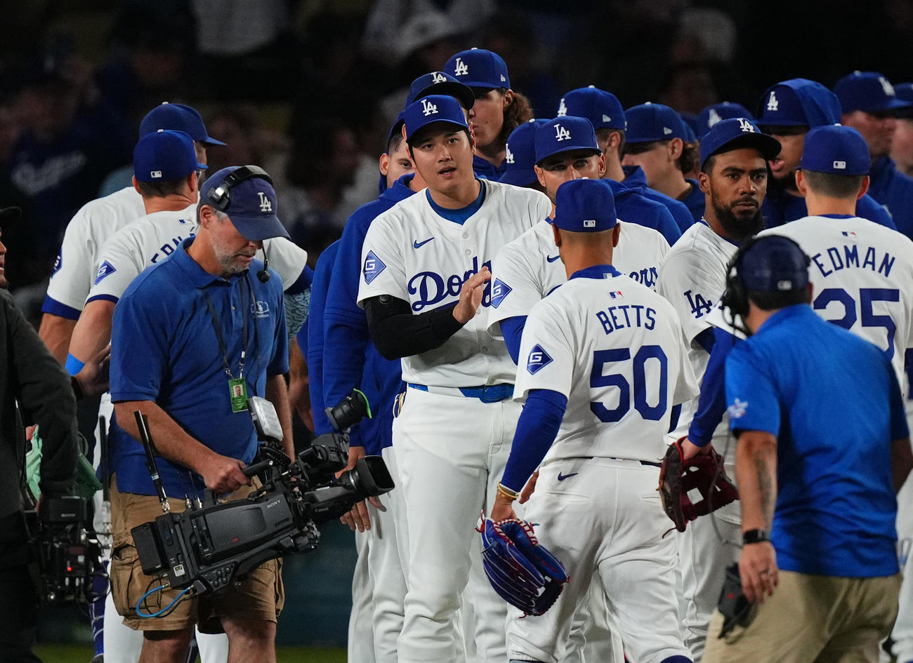 ドジャース対パドレス　地区優勝に王手をかけ、ナインとタッチをするドジャース大谷（中央）（撮影・菅敏）