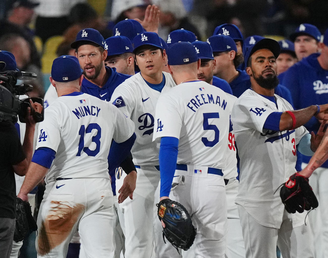 ドジャース対パドレス　地区優勝に王手をかけ、ナインとタッチをするドジャース大谷（中央）（撮影・菅敏）