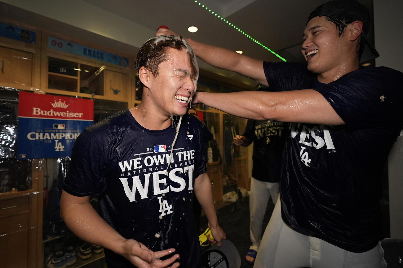 地区優勝を決め、大谷翔平（右）からシャンパンをかけられる山本由伸（AP）