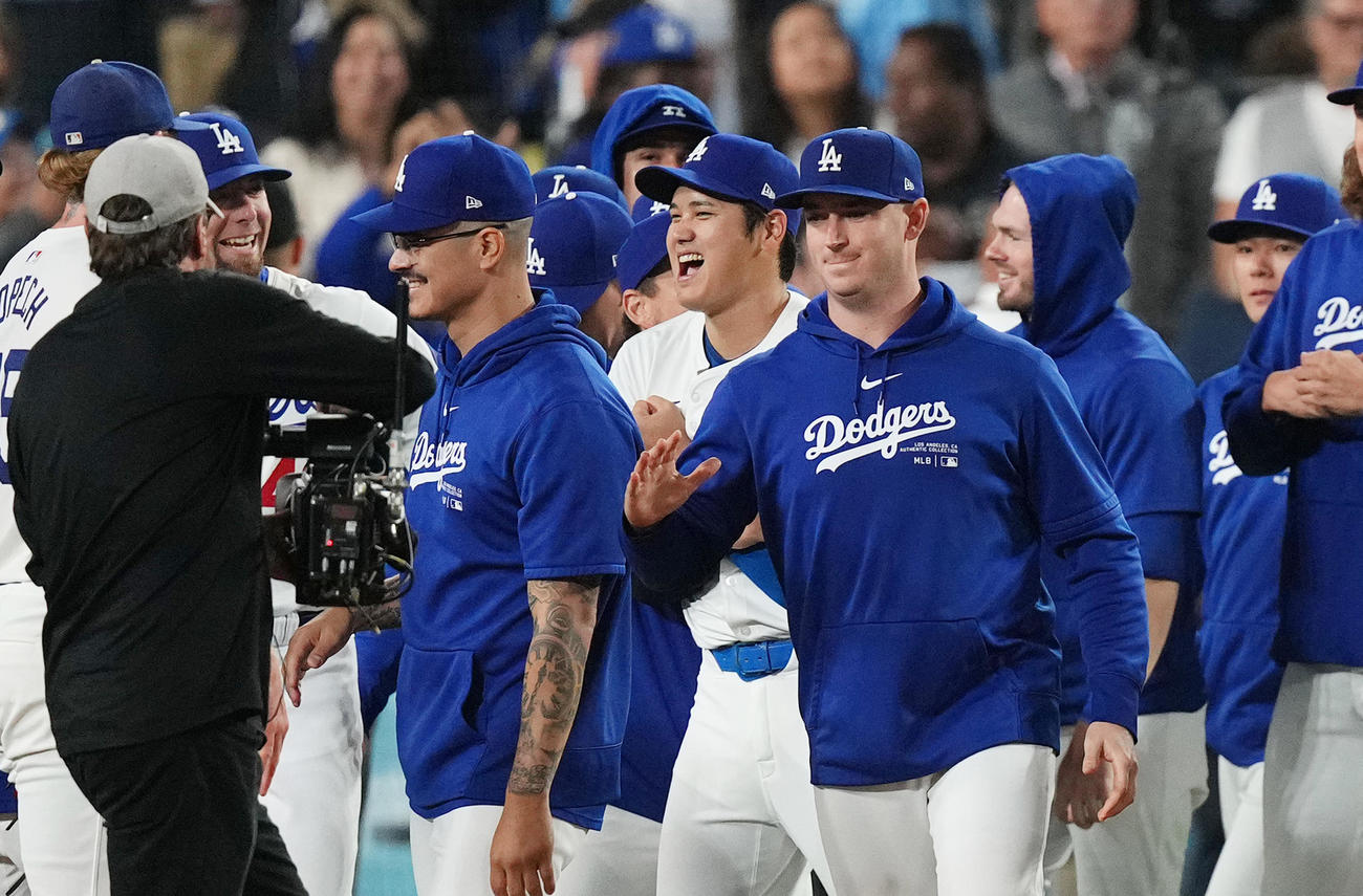 ドジャース対パドレス　地区優勝を決め、笑顔でナインとタッチをする大谷（中央）（撮影・菅敏）