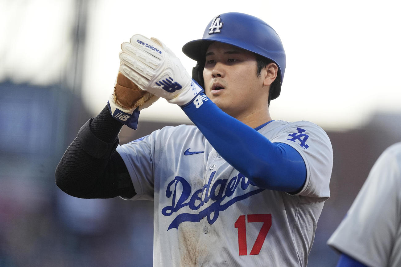 大谷翔平はロッキーズ戦の1回表、一塁に滑り戻った後、グローブを拭いた（AP）