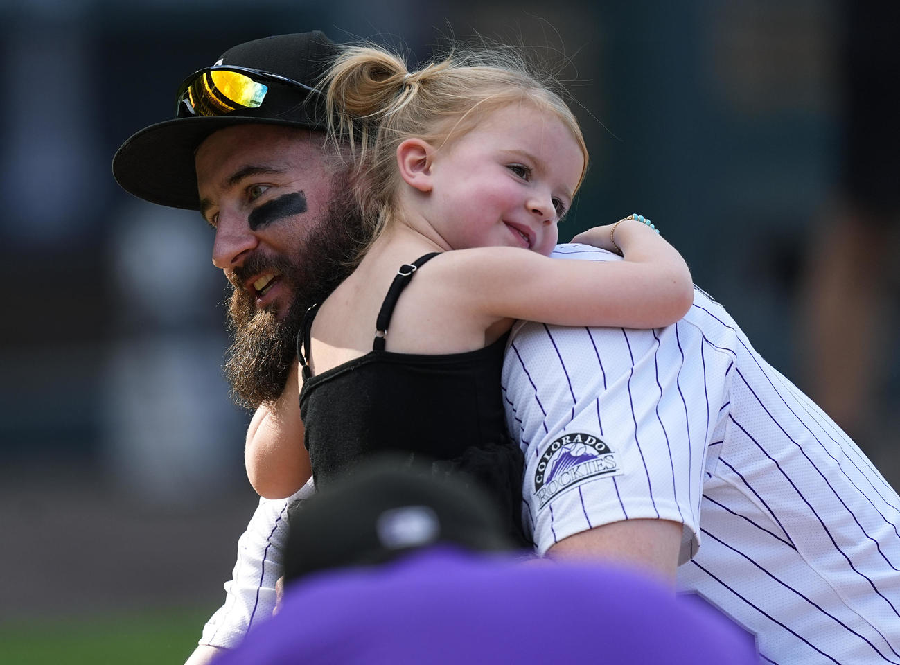 娘を抱きしめる今季で引退のロッキーズ・ブラックモン（AP）