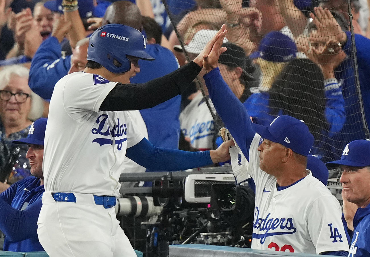 ドジャース対パドレス　4回裏ドジャース2死満塁、T・ヘルナンデスの2点適時打で三塁から生還し、ロバーツ監督（右）にタッチで迎えられる大谷（撮影・菅敏）