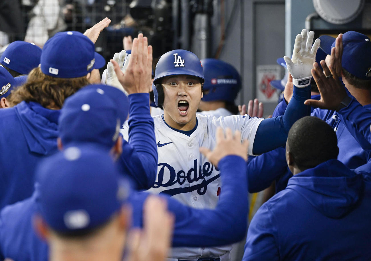 米大リーグ、パドレス戦の2回にポストシーズン初本塁打となる同点3ランを放ち、ベンチで祝福されるドジャースの大谷翔平（共同）