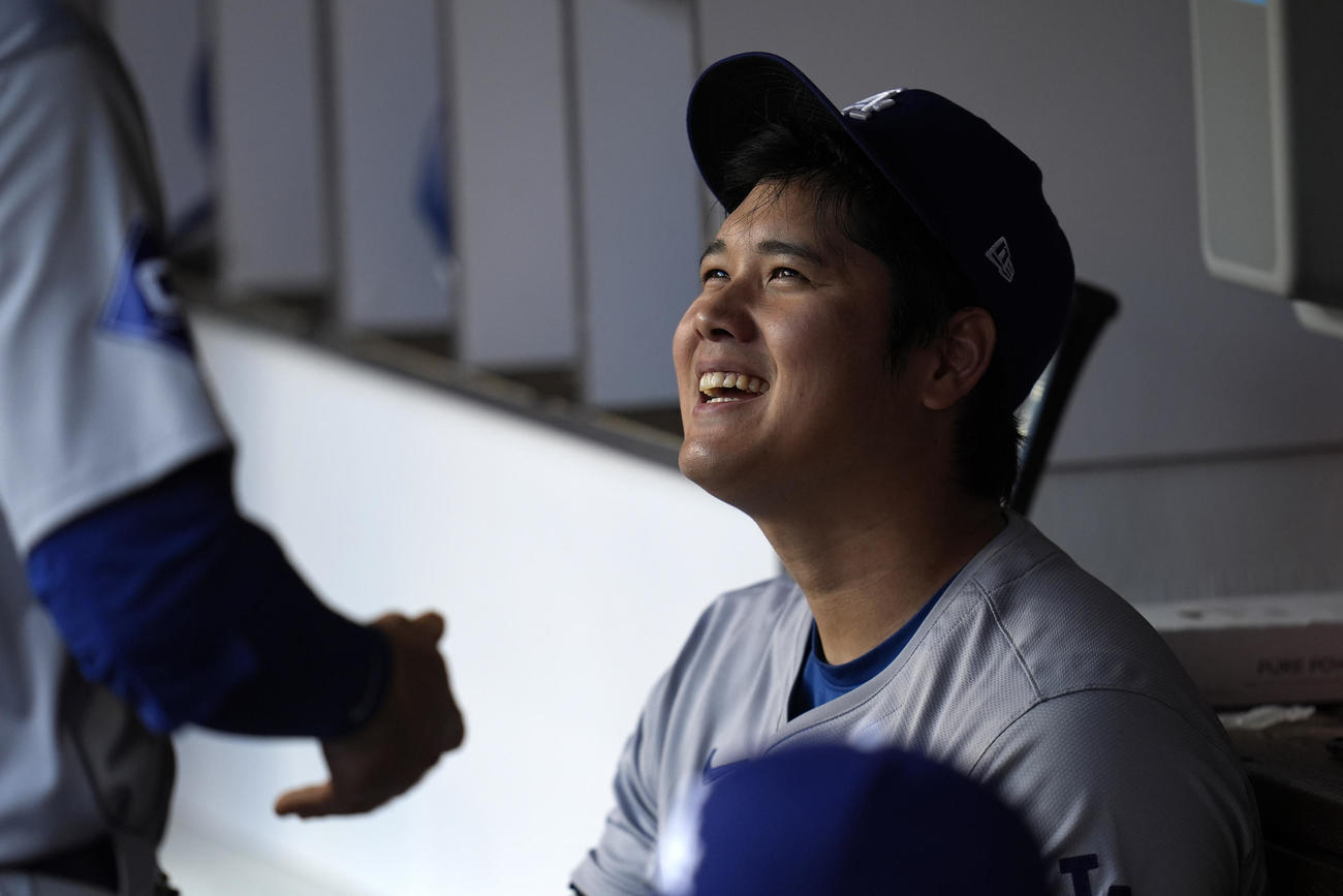 大谷翔平はパドレスとの地区シリーズ第3戦の試合前にベンチで笑顔を見せた（AP)
