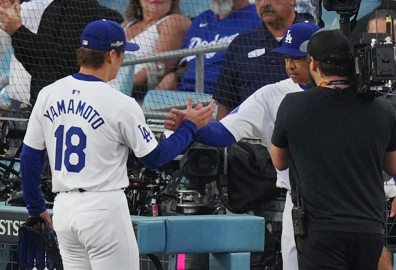 ドジャース対パドレス　5回を投げ終え、ロバーツ監督（右）に握手で迎えられる山本（撮影・菅敏）