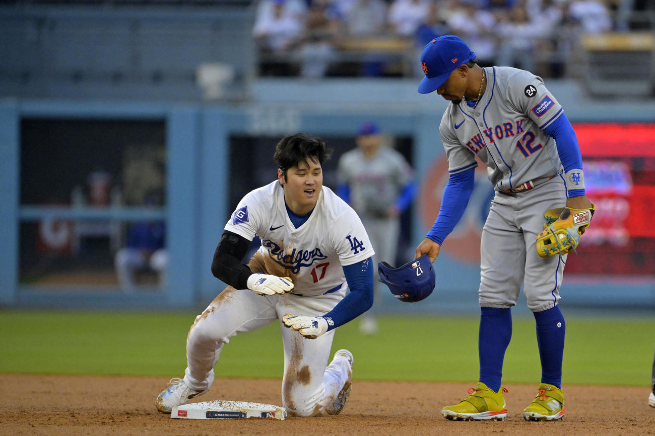 ドジャース対メッツ　2回、二投に失敗したドジャース大谷翔平（左）に脱げたヘルメットを手渡すメッツのリンドア（ロイター）