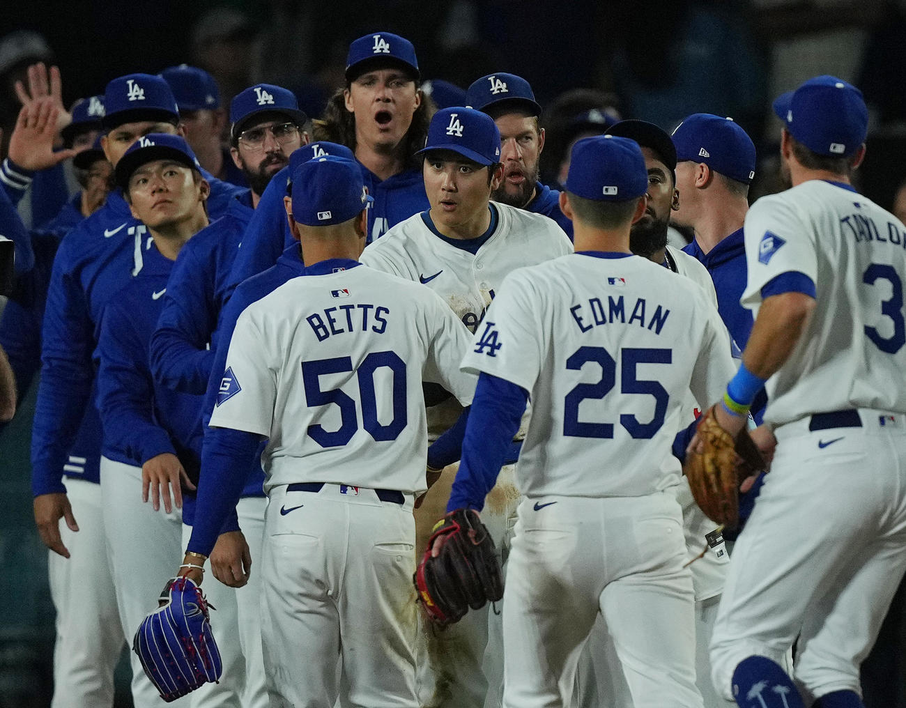 リーグ優勝決定シリーズ第1戦を白星で飾り、ナインとタッチをするドジャース大谷（中央）（撮影・菅敏）