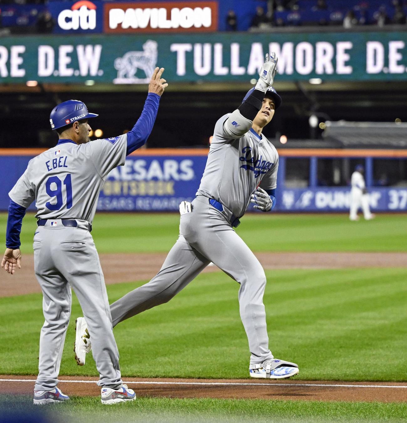 2試合連続本塁打となる先制ソロを放ち、三塁コーチとタッチするドジャース・大谷＝（共同）