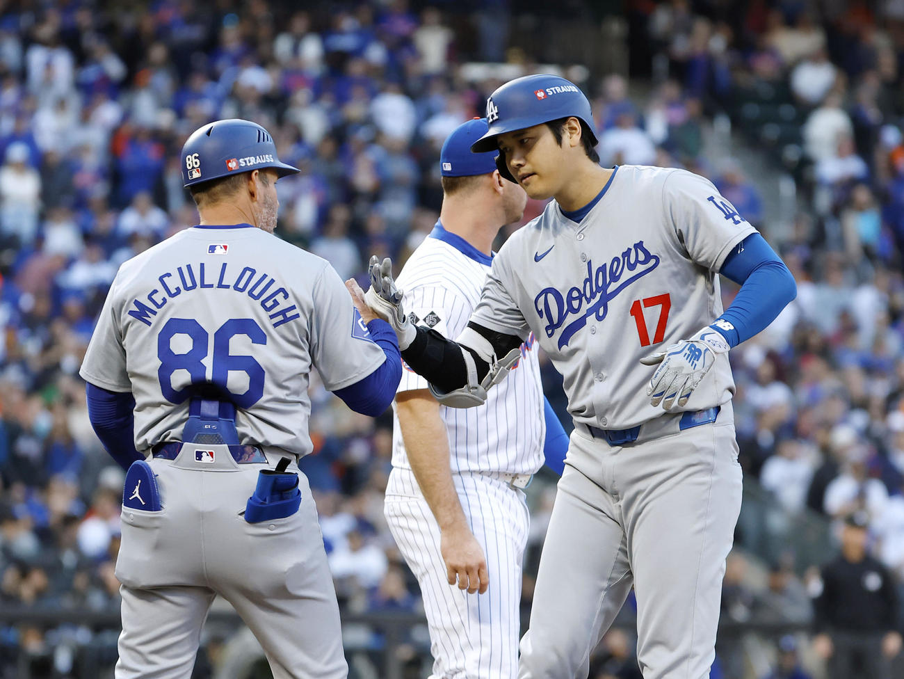 メッツ戦の1回、右前打を放ち一塁コーチとタッチするドジャース・大谷＝ニューヨーク（共同