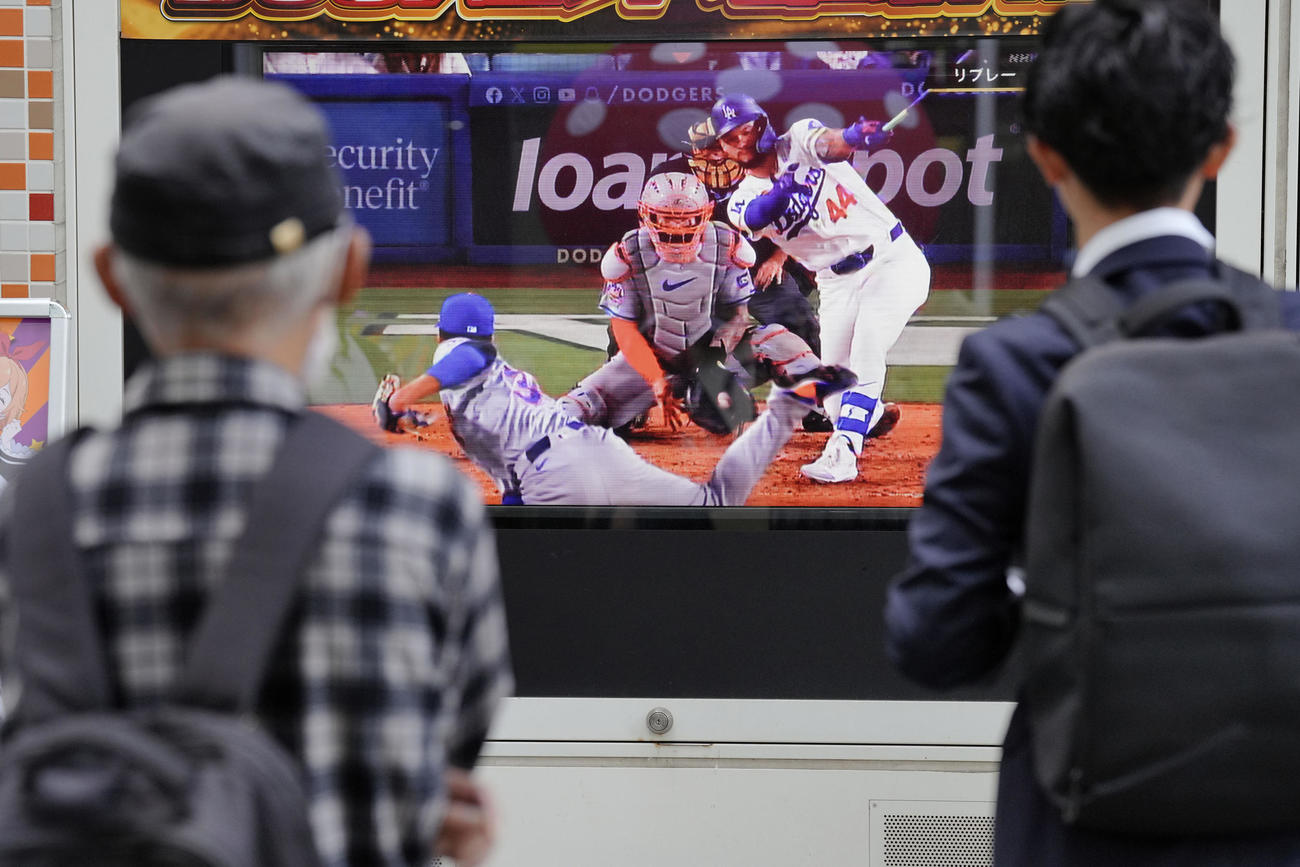 東京の街頭テレビでドジャース対メッツを観戦する歩行者ら（AP）
