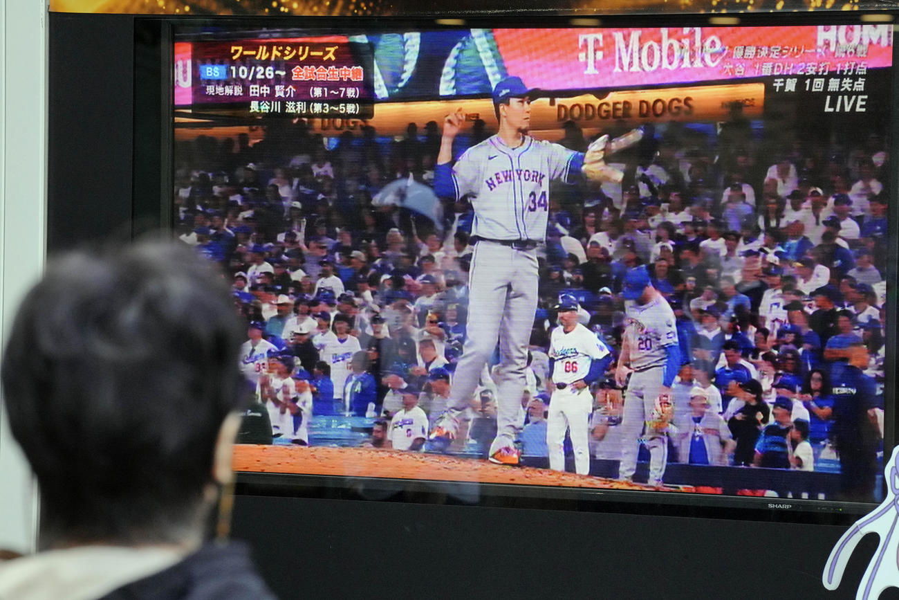 東京の街頭テレビでドジャース対メッツ戦に登板する千賀滉大の投球を観戦する歩行者（AP）