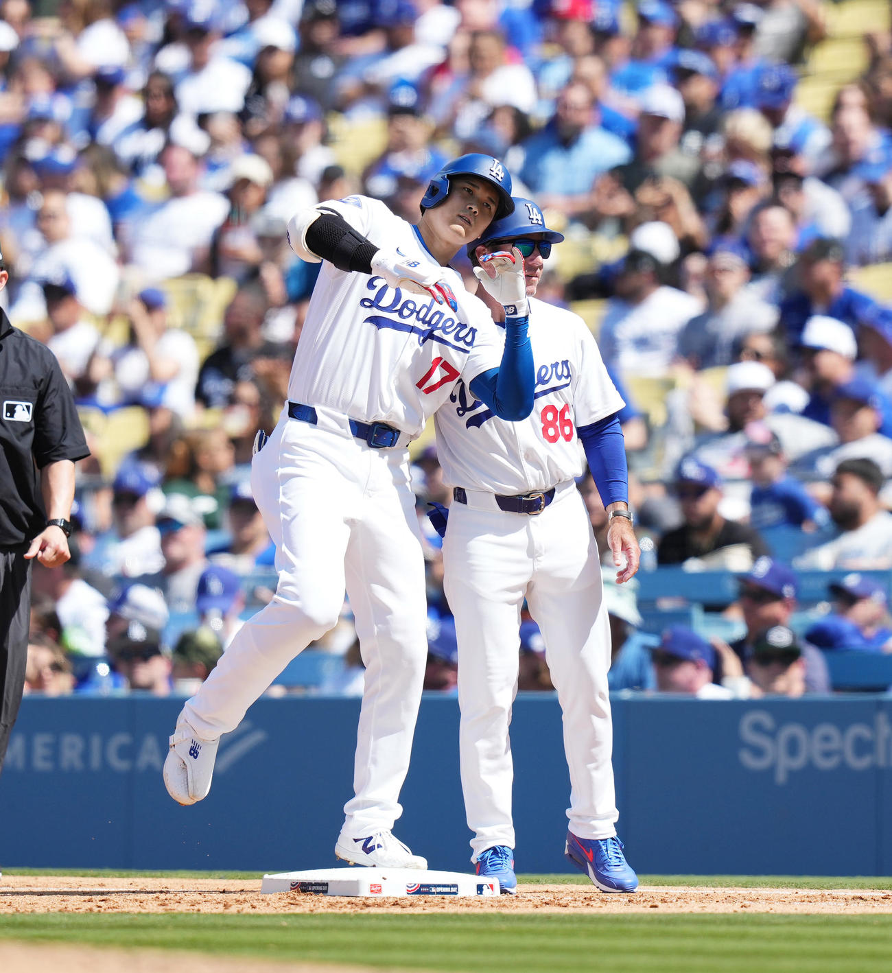 ドジャース対カージナルス　5回裏ドジャース1死、右安打を放ち、マッカロー一塁走塁コーチ（右）とヘルメットでタッチをする大谷（2024年3月28日撮影）