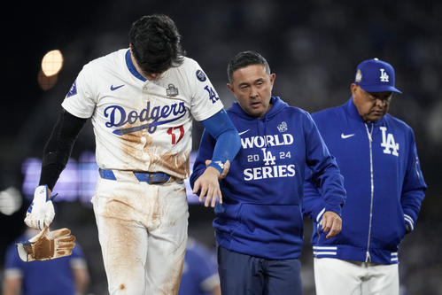 ドジャース対ヤンキース　7回裏、盗塁を試みた際に左腕付近を負傷し、引き揚げるドジャース大谷翔平（左）。右はロバーツ監督 (AP)