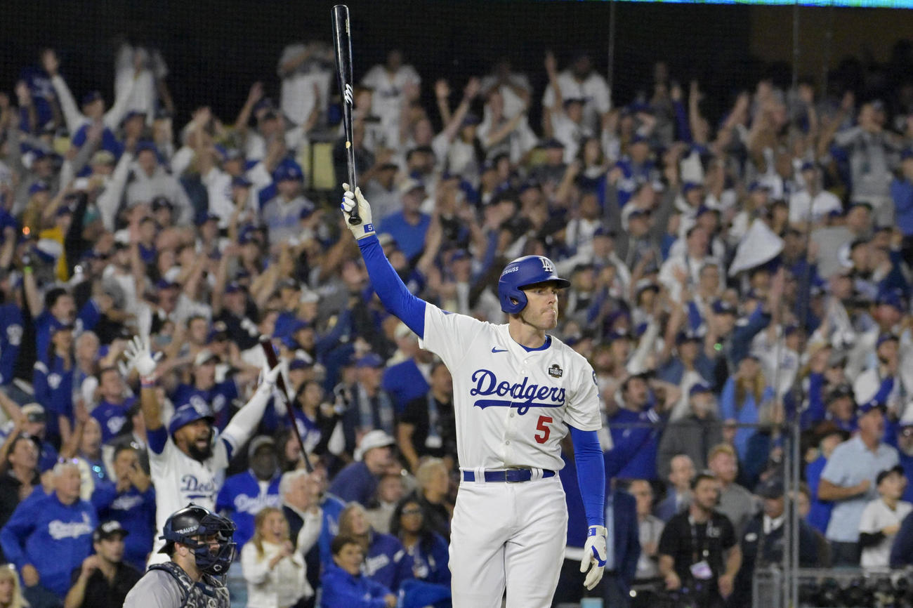 ドジャース対ヤンキース　10回、逆転満塁本塁打を放ったドジャースのフリーマンは打球の行方を見つめながらバットを高々と掲げる（ロイター）