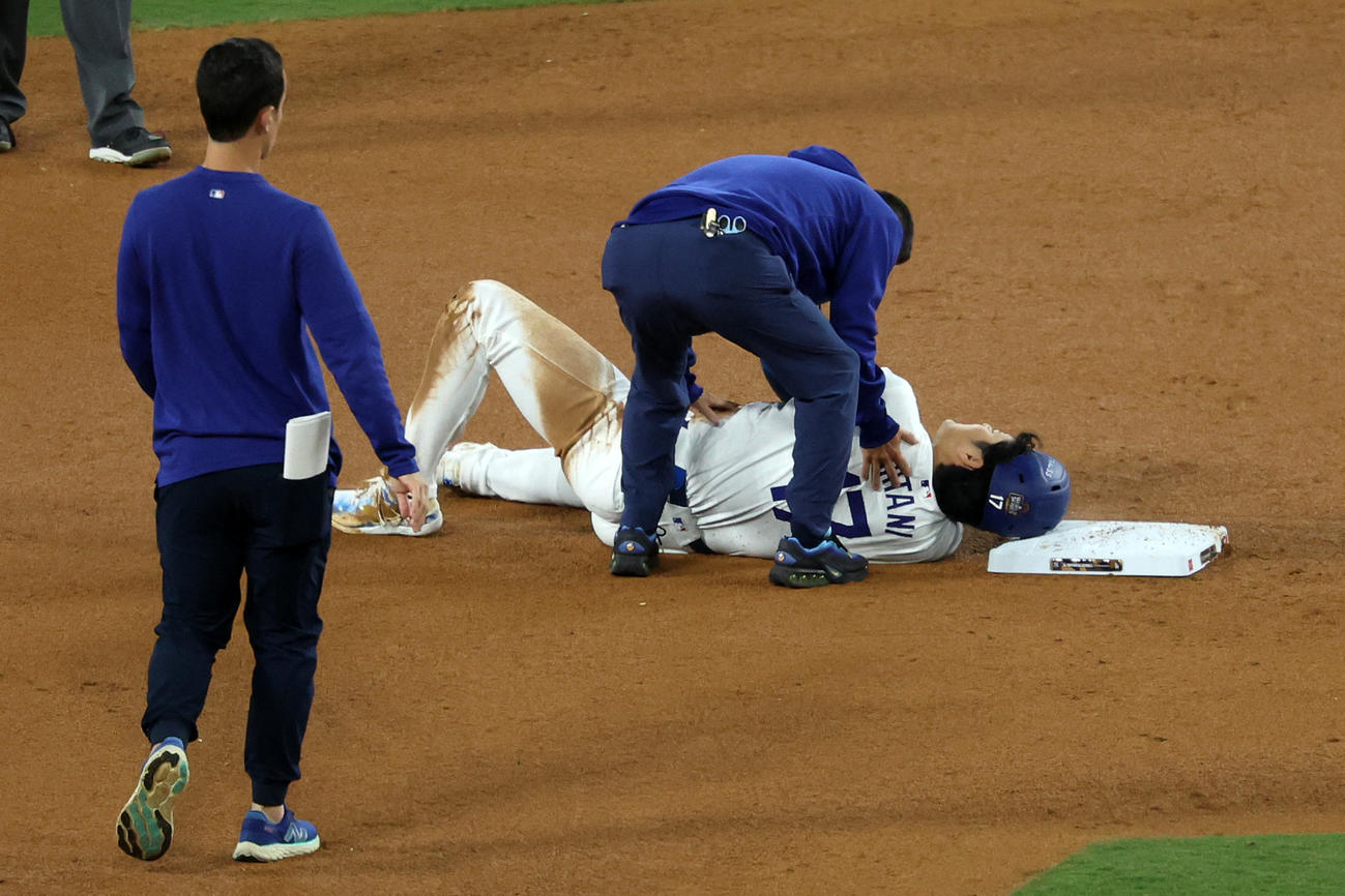 ヤンキース戦の7回、二盗を試みた際に左肩付近を負傷して倒れ込むドジャース大谷と駆け寄るスタッフ（ロイター）