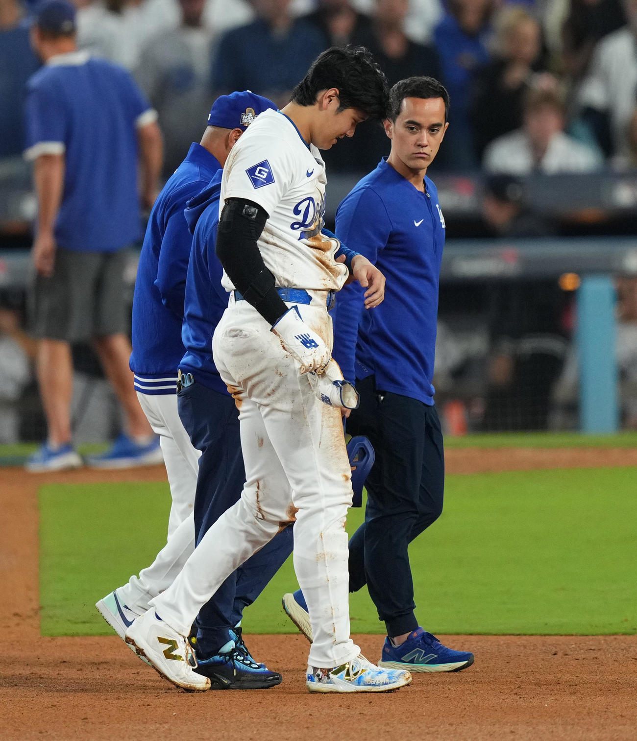 ドジャース対ヤンキース　7回裏ドジャース2死一塁、二塁盗塁を狙うもアウトとなった大谷は、左手を負傷しロバーツ監督（後方）に付き添われベンチに戻る（撮影・菅敏）