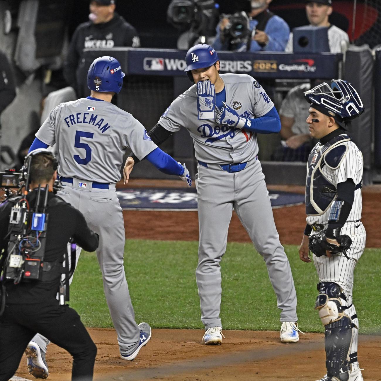 ヤンキース戦の1回、フリーマンの先制2ランで生還し、迎えるドジャース大谷＝ニューヨーク（共同）