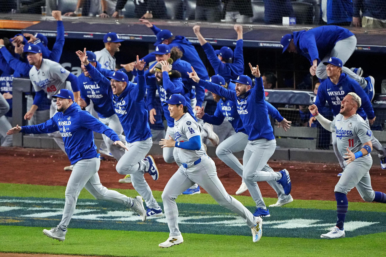 ワールドシリーズ制覇を決めマウンドめがけて駆け出す大谷翔平（中央）らドジャースの選手たち（ロイター）