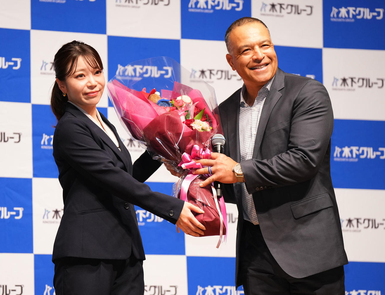 木下グループの新CMに出演し、制作発表会で花束を受け取るドジャース・ロバーツ監督（右）（撮影・菅敏）