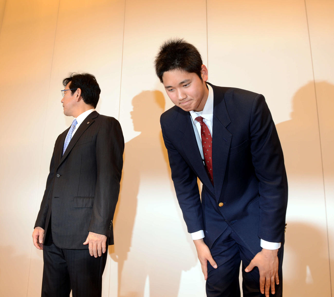 2012年12月9日、日本ハム入りを表明した大谷は会見の後、報道陣に頭を下げる。左は栗山監督