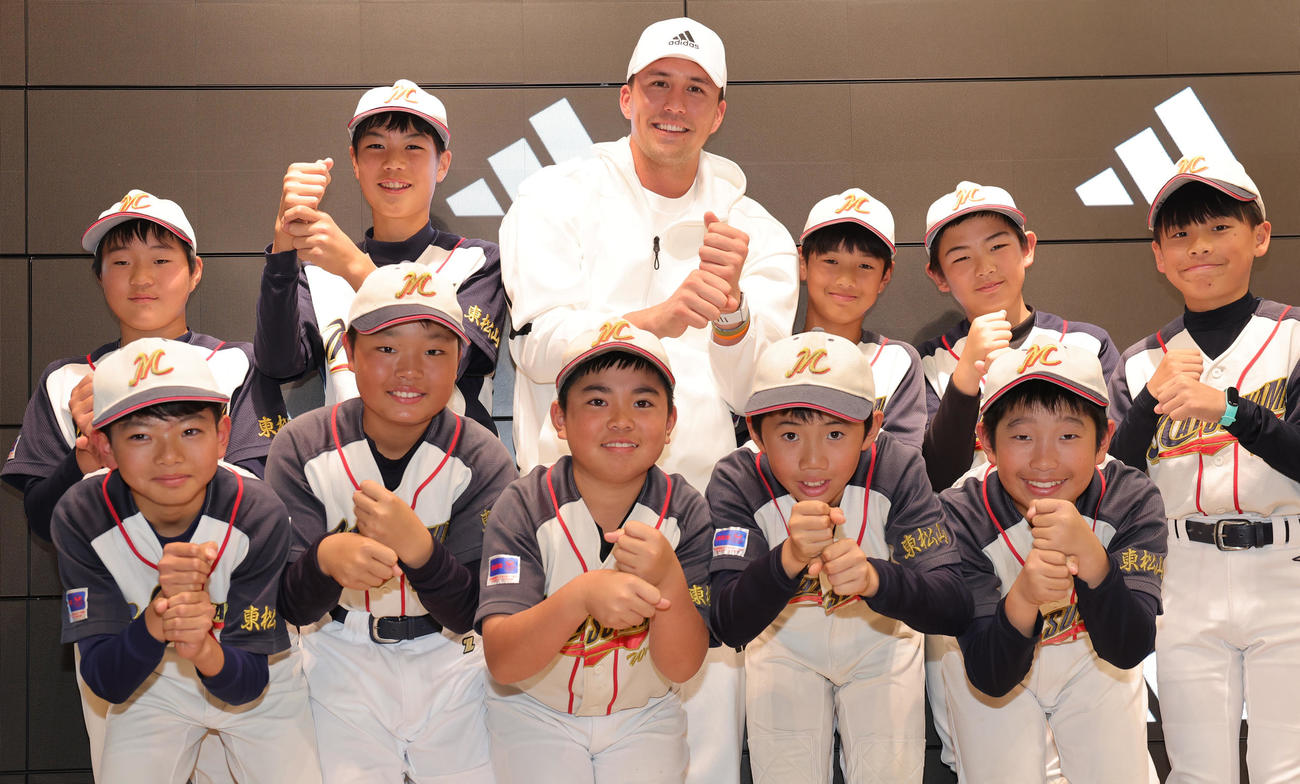 アディダスジャパンの来店イベントで、松山西ジャイアンツの子どもたちとペッパーミルポーズで記念撮影するカージナルスのヌートバー（撮影・野上伸悟）
