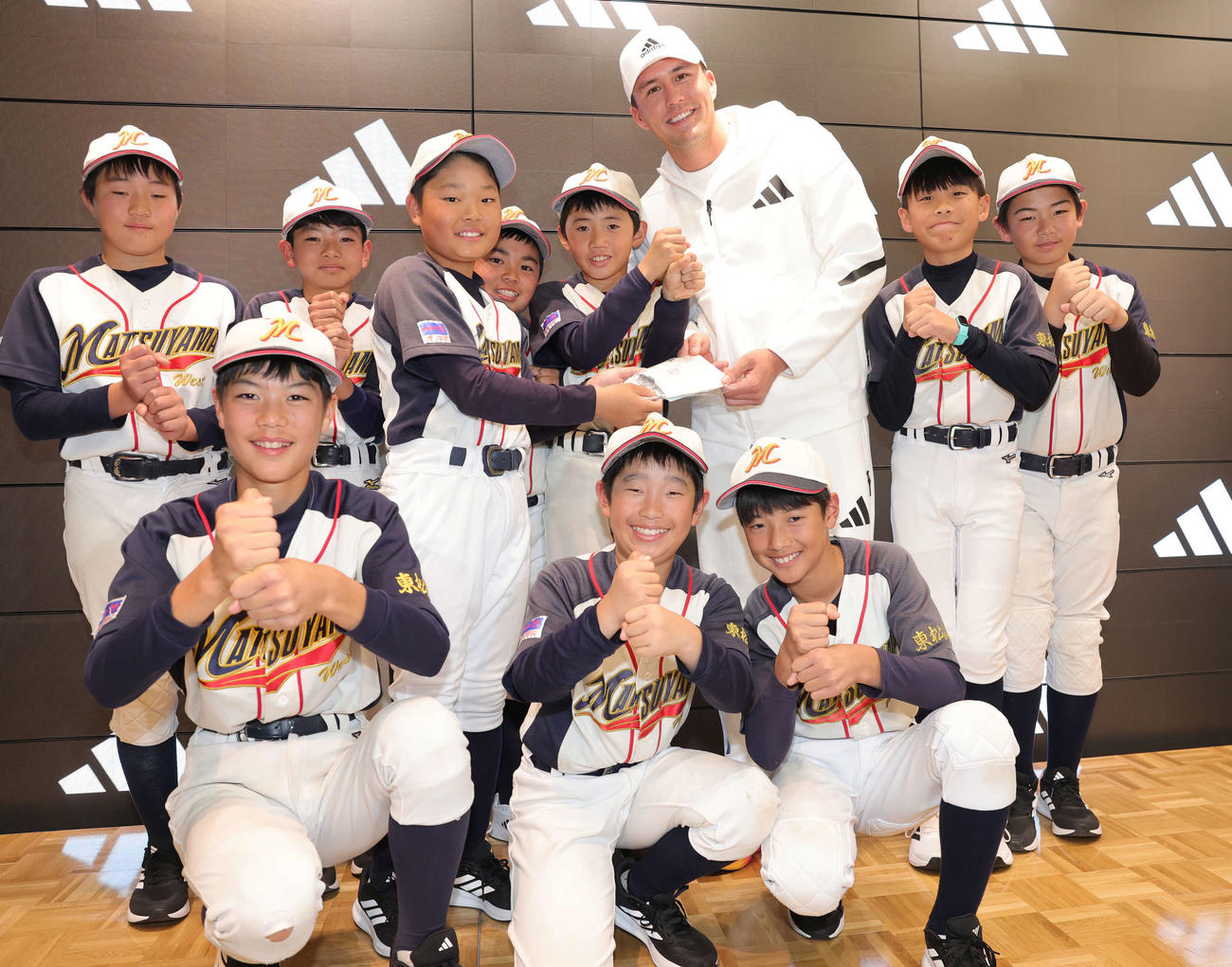 アディダスジャパンの来店イベントで、松山西ジャイアンツの子どもたちからお守りをもらうカージナルスのヌートバー（撮影・野上伸悟）