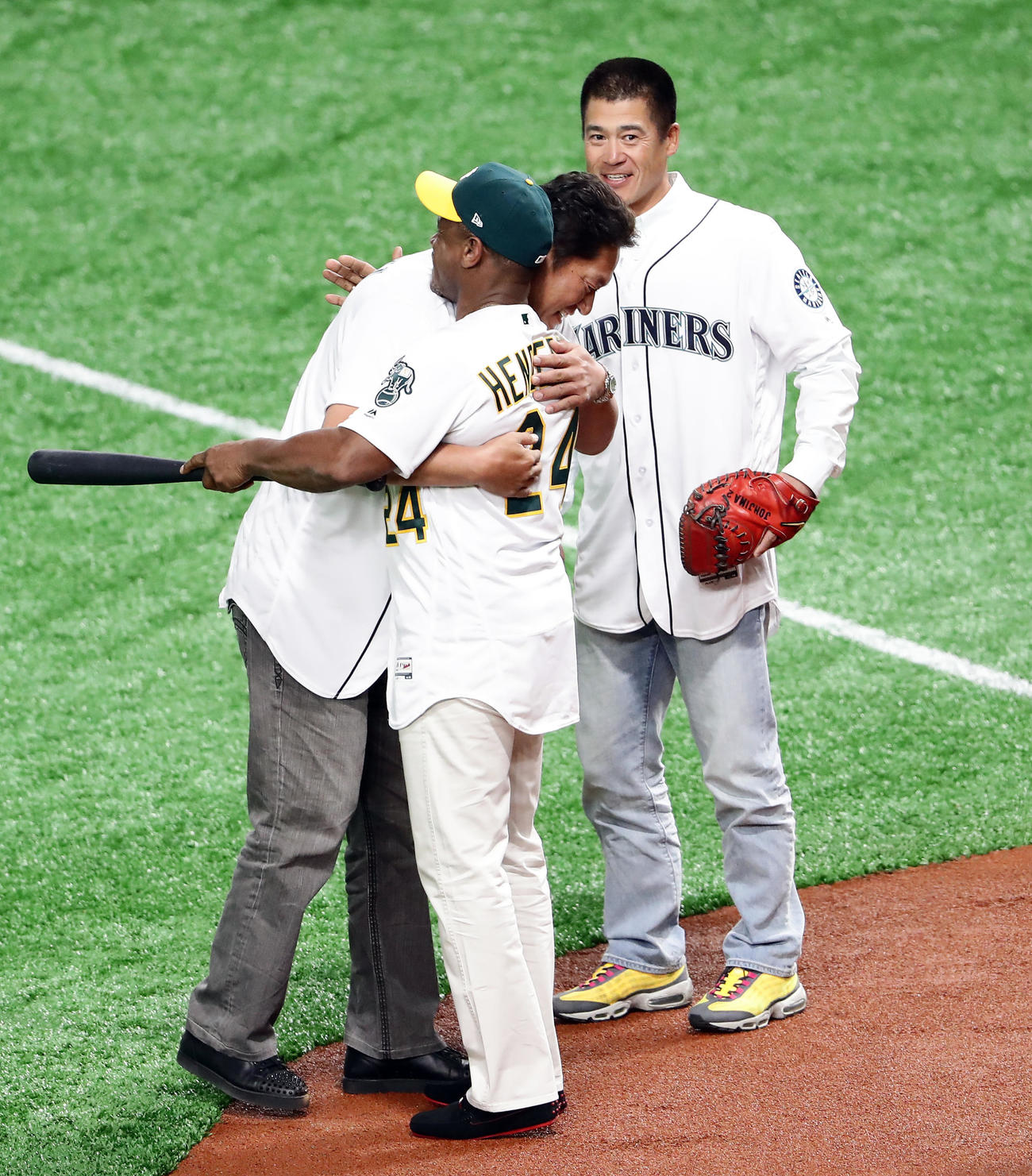 19年3月、MLBア・リーグ開幕戦で始球式に登場した佐々木氏（左）は打席に立ったヘンダーソンさんと抱き合う。後方は捕手を務めた城島氏