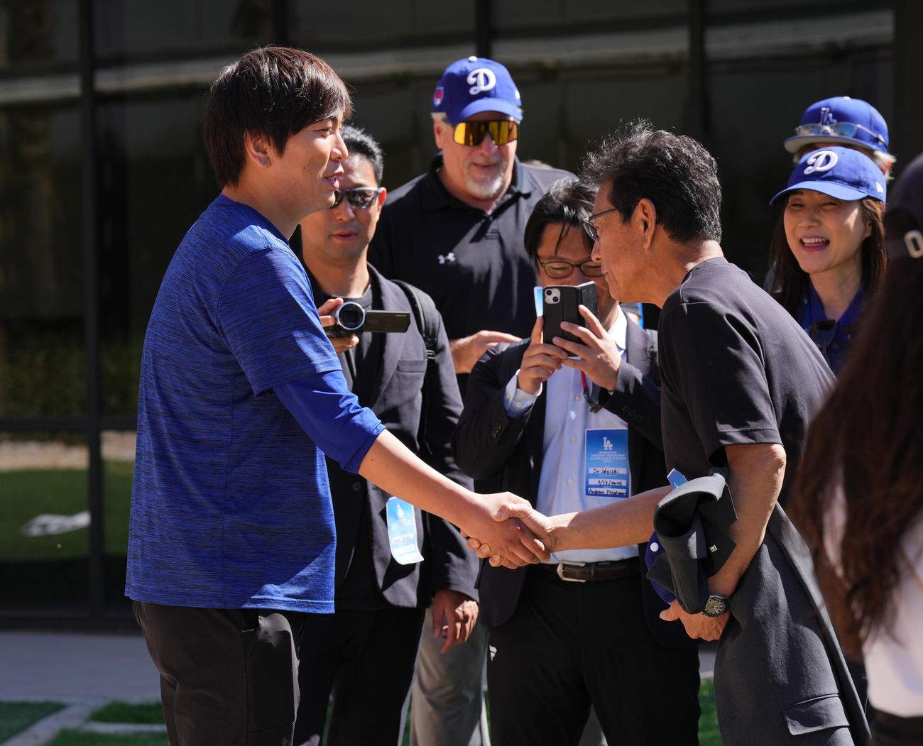 キャンプ地を訪れた栗山侍ジャパン前監督（右）と握手をする水原通訳（撮影・菅敏）