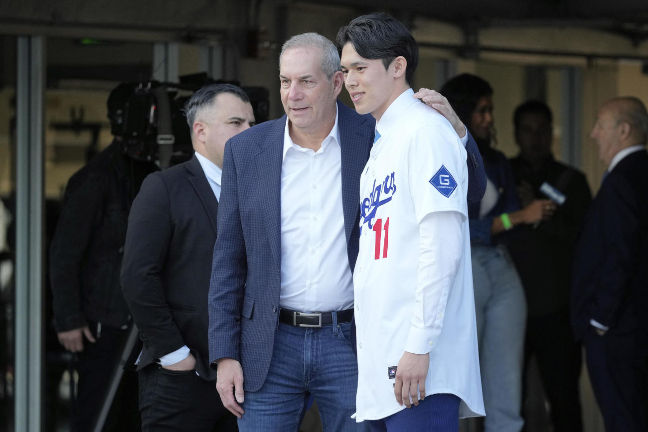 ドジャース入団会見後、代理人ジョエル・ウルフ氏（左）とともにポーズをとる佐々木朗希（AP）