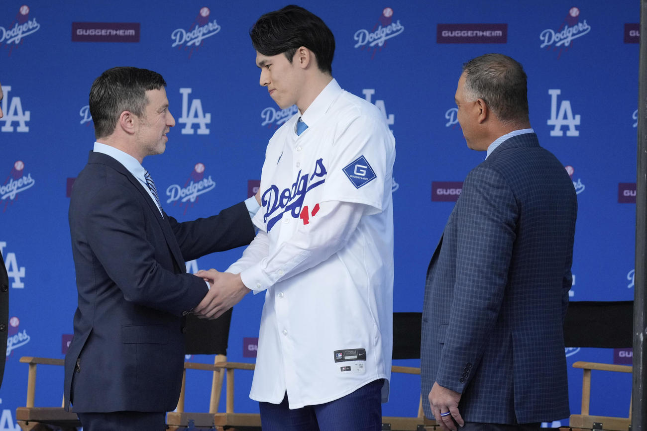 ドジャース入団会見でアンドリュー・フリードマン編成本部長（左）と握手する佐々木朗希（中央）（AP）