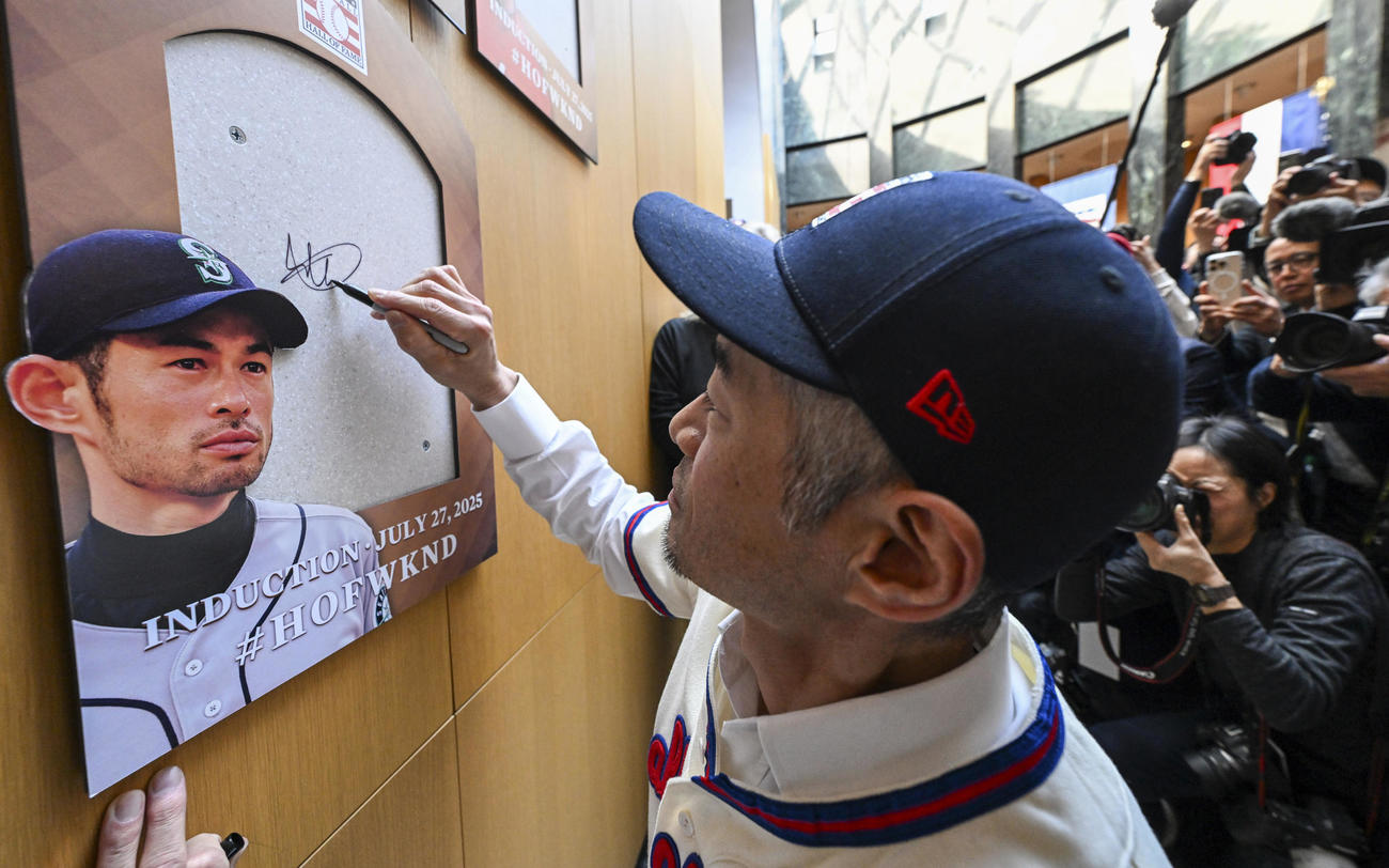 米国野球殿堂入りし、殿堂博物館で自身の写真入りプレートにサインするイチロー氏（AP）