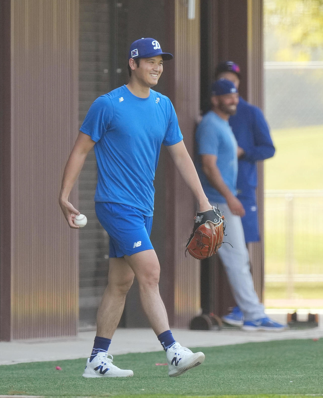 キャンプ地でキャッチボールをするドジャース大谷は、フィールドに登場したかわいいワンちゃんを室内練習場に誘導し、笑顔を見せる（撮影・菅敏）