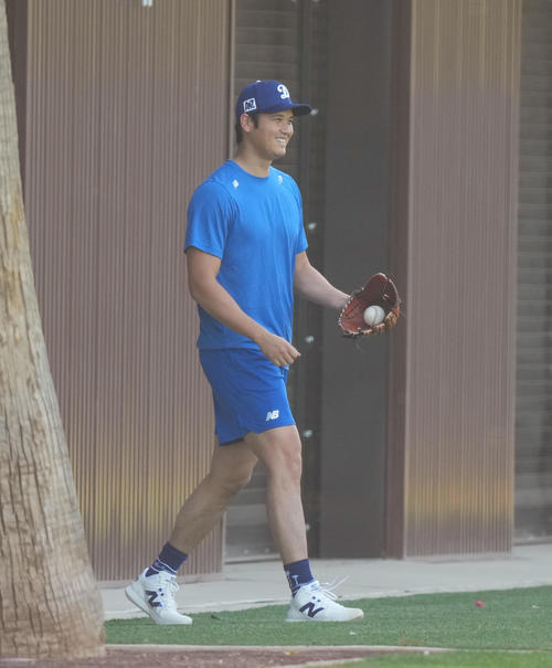 キャンプ地でキャッチボールをするドジャース大谷は、フィールドに登場したかわいいワンちゃんを室内練習場に誘導し、笑顔を見せる（撮影・菅敏）