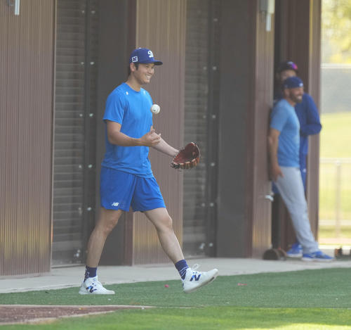 キャンプ地でキャッチボールをするドジャース大谷は、フィールドに登場したかわいいワンちゃんを室内練習場に誘導し、笑顔を見せる（撮影・菅敏）