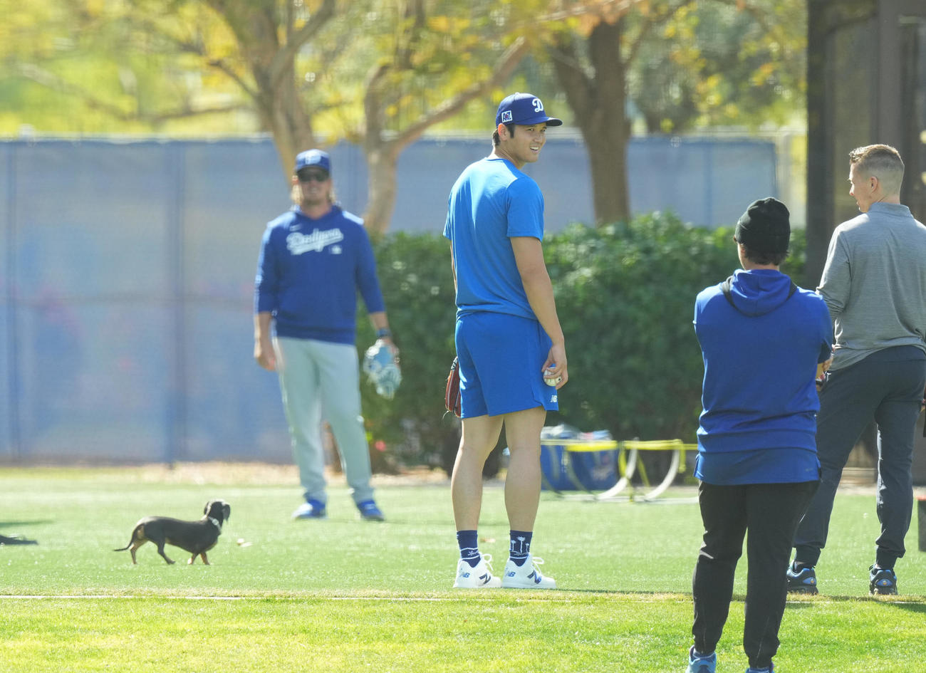 キャンプ地でキャッチボールをするドジャース大谷（中央）は、フィールドに登場したかわいいワンちゃんを前に笑顔を見せる（撮影・菅敏）