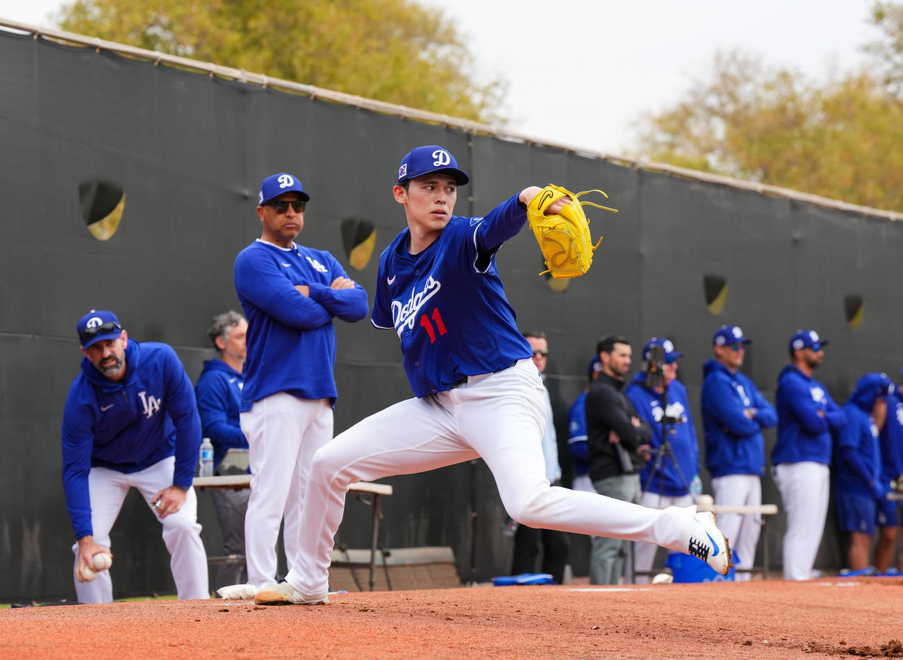 ドジャース春季キャンプ　デーブ・ロバーツ監督（左から2人目）が見守る中、ブルペンで投球練習をするドジャース佐々木（撮影・菅敏）