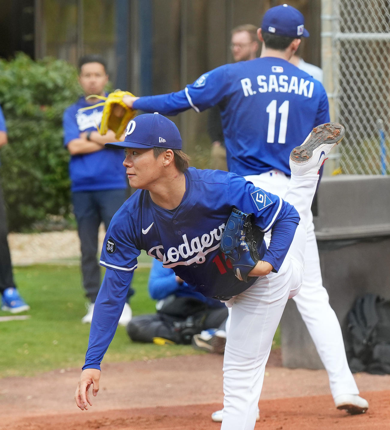 ブルペンで佐々木（後方）と並んで投球練習をするドジャース山本（撮影・菅敏）