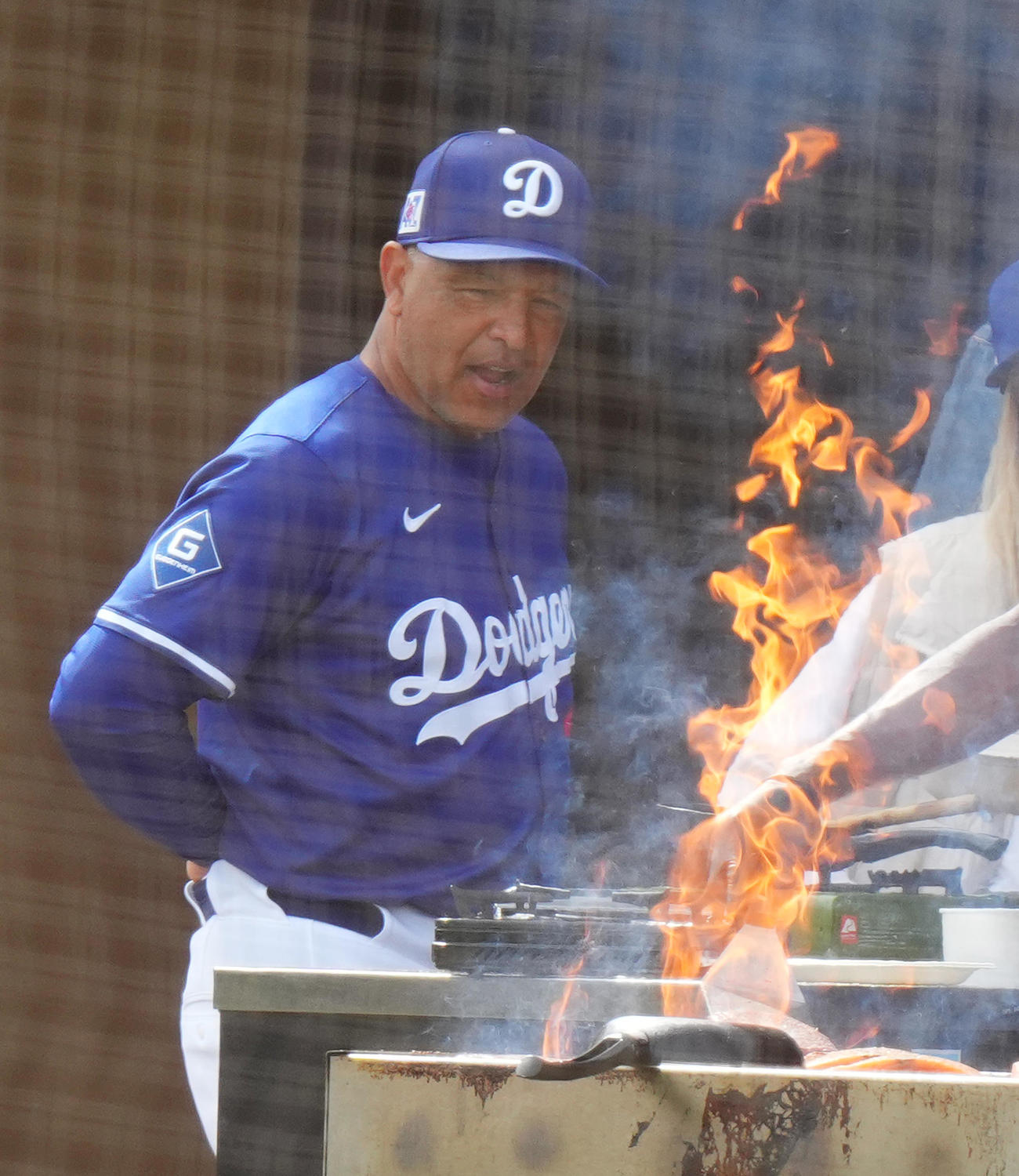 2月16日、キャンプ地のBBQコンロから上がる炎を前にするドジャース・ロバーツ監督（撮影・菅敏）