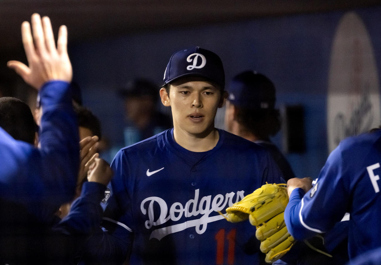 オープン戦・ドジャース対レッズ　レッズとのオープン戦に登板したドジャース佐々木朗希はベンチでチームメートとハイタッチ（ロイター）
