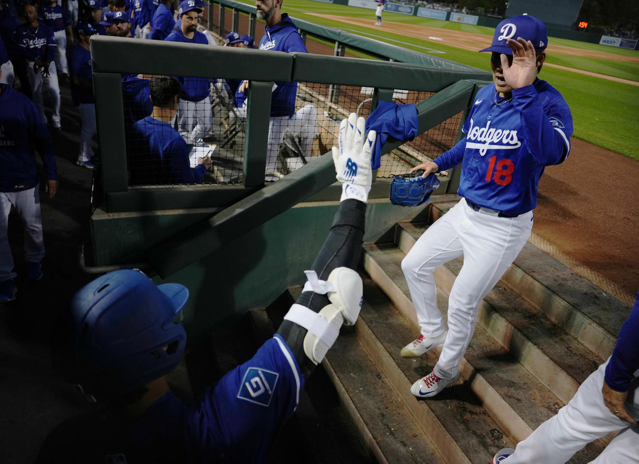 オープン戦・ドジャース対レッズ　2回の投球を終え、大谷（手前）にタッチで迎えられるドジャース山本（撮影・菅敏）