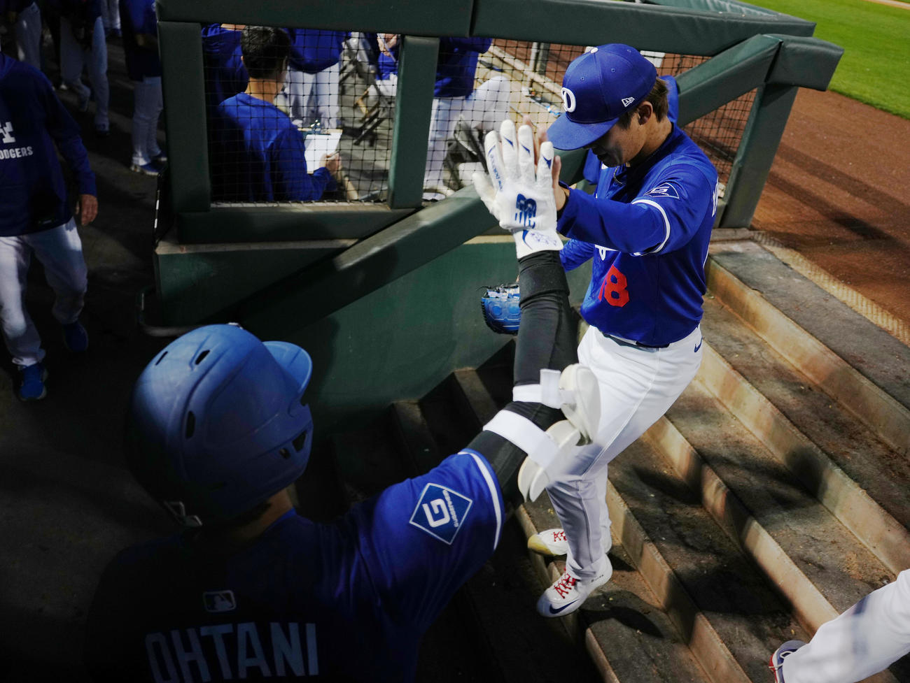 オープン戦・ドジャース対レッズ　2回の投球を終え、大谷（手前）にタッチで迎えられるドジャース山本（撮影・菅敏）