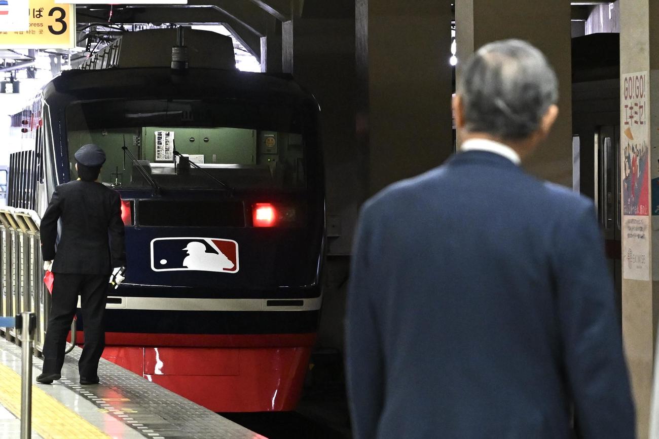 出発したMLBカラーにラッピングされた列車を見送るマッシー村上氏（手前）（撮影・滝沢徹郎）
