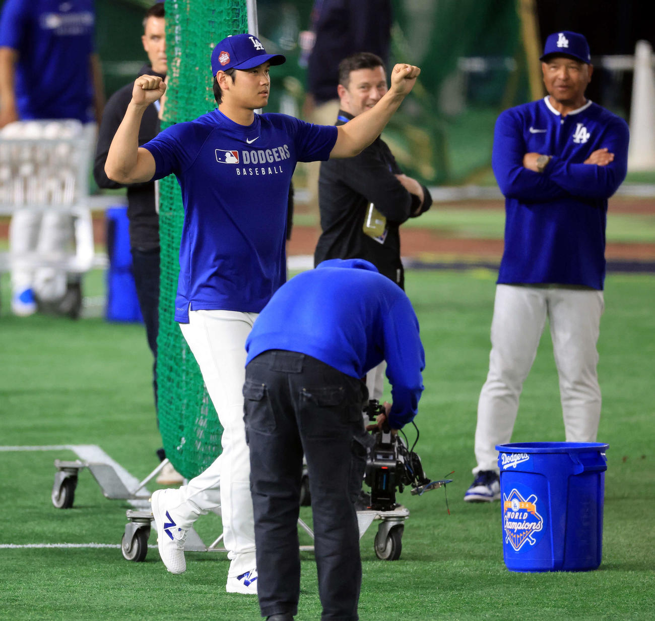 グラウンドに出たドジャース大谷は声援にガッツポーズ。後方はロバーツ監督（浅見桂子）