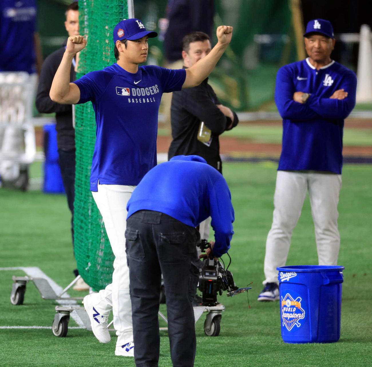 グラウンドに出たドジャース大谷は声援にガッツポーズ。後方はロバーツ監督（浅見桂子）