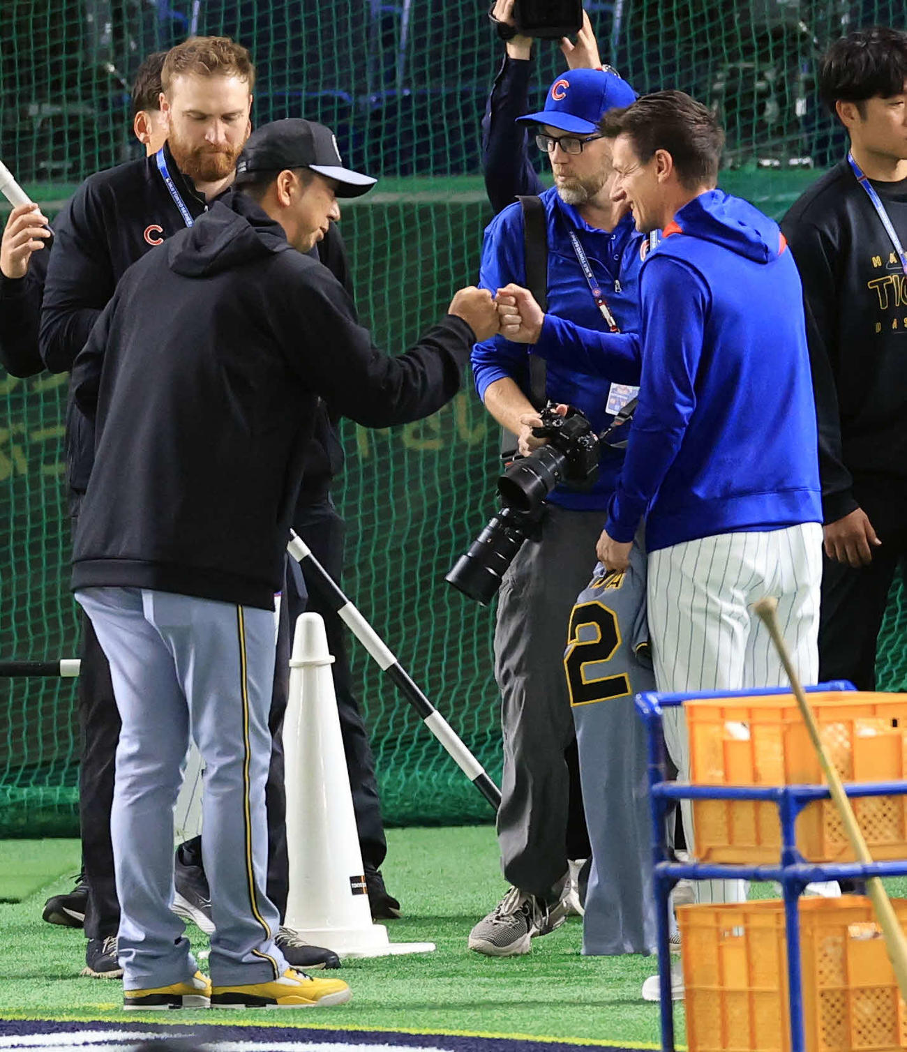 阪神対カブス　試合前練習中、ユニホームの交換をした阪神藤川監督（左）とカブスのカウンセル監督はグータッチ（撮影・浅見桂子）