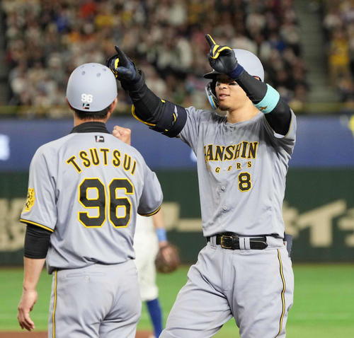 阪神対カブス　5回裏阪神1死一、二塁、佐藤輝は右適時打を放ちベンチを指す（撮影・小沢裕）